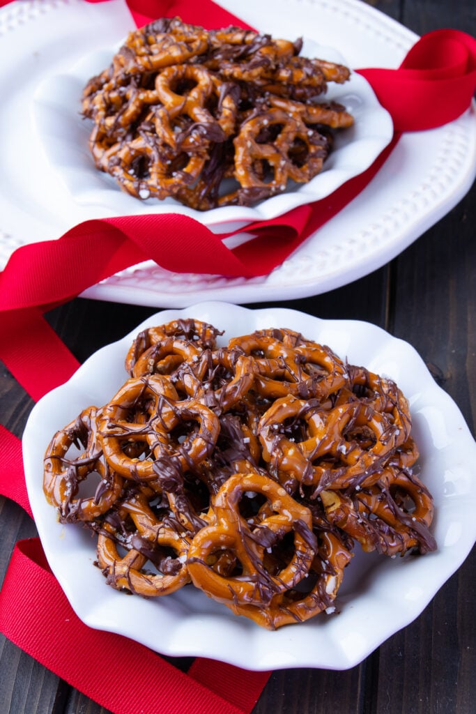 With the perfect balance of sweet and salty, these Chocolate Caramel Pretzels and piled high in a shallow white bowl waiting for you to take a bite!