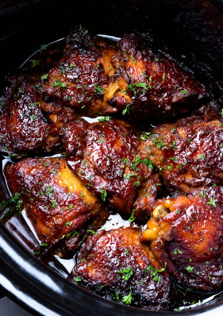 Chicken Thighs in rich, thick sauce cooked in the crock pot and sprinkled with fresh parsley.
