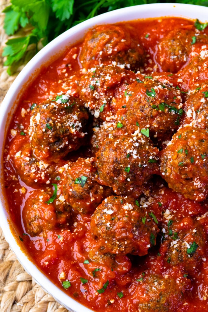 Homemade ground beef meatball in tomato sauce in a bowl.