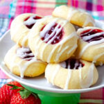 6 Jam Thumbprint Cookies on a small cake stand served with strawberries.