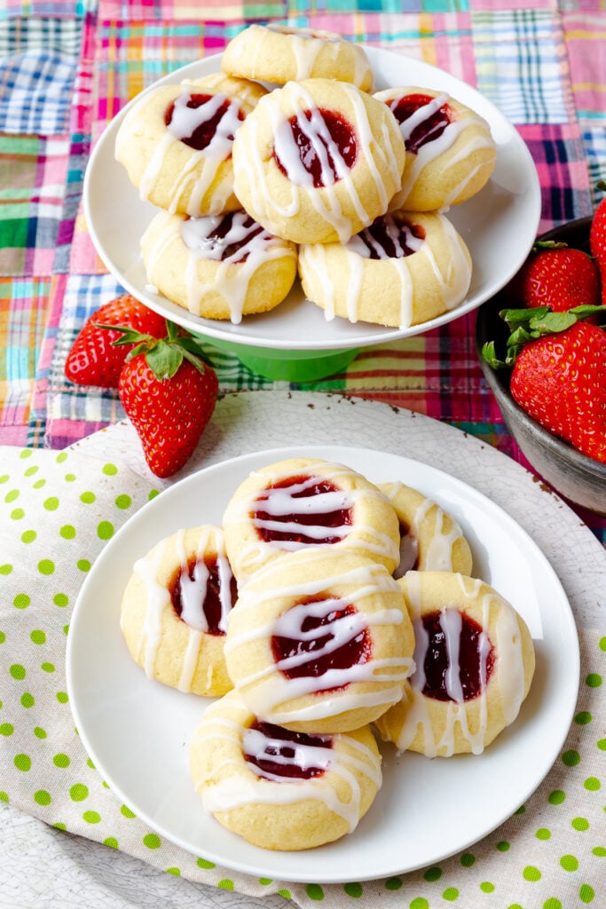 Jam Thumbprint Cookies on a plate and a small green stand with strawberries.