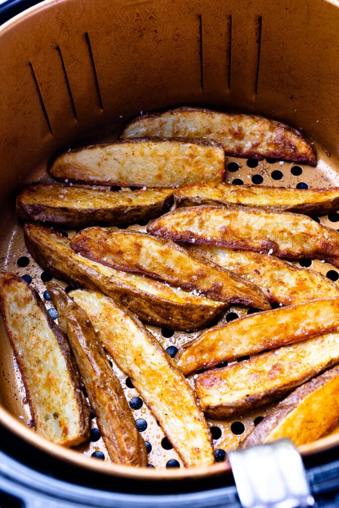 Potato Wedges cooked in the basket of the air fryer.