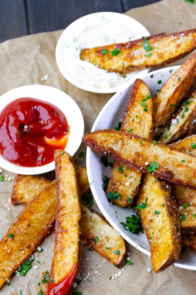 Seasoned potato wedges made in the air fryer served with ketchup and chive aioli.