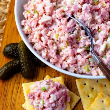 Ham Salad in a bowl with a spoon and pickles and crackers