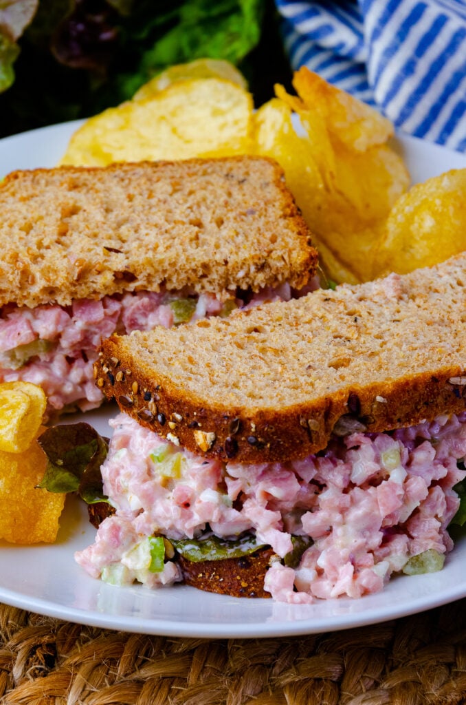 Ham Salad with lettuce on wheat bread served with potato chips.