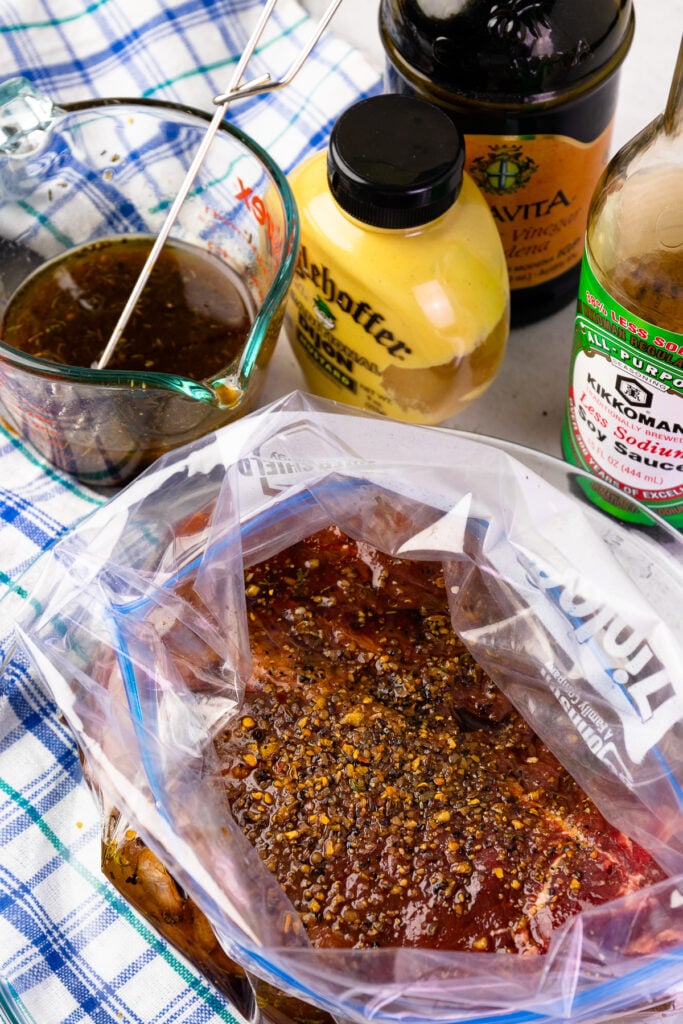 London Broil in bag with indgredients and a measuring cup.