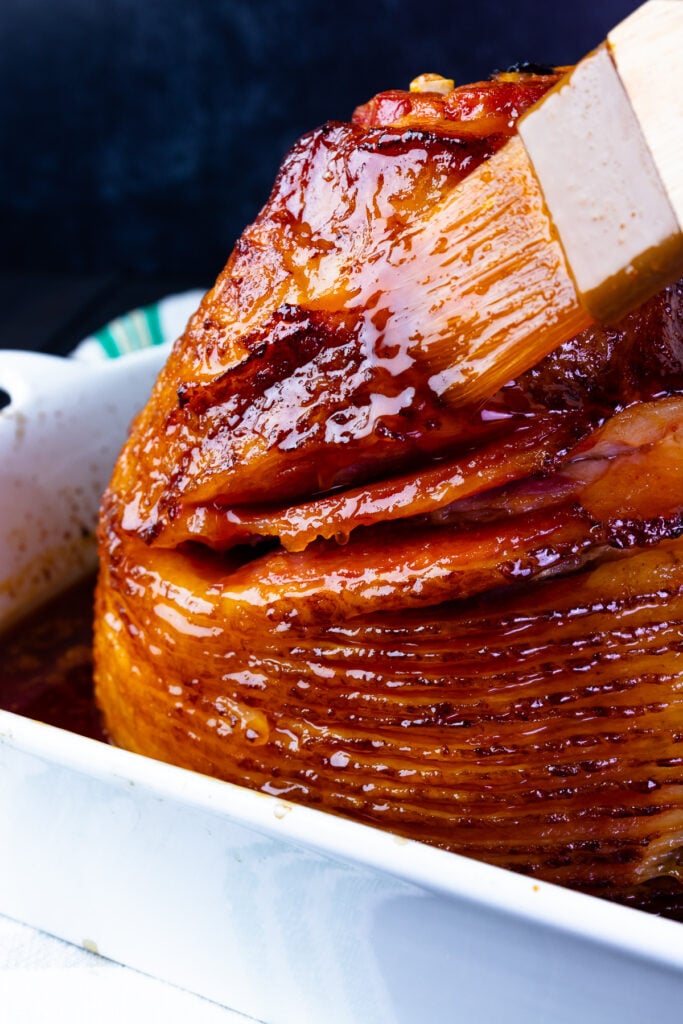 Orange and Red Pepper Jelly Glazed Ham is baked in a baking dish is juicy and sweet.