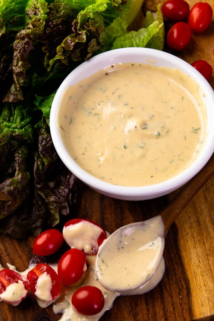 Garlic Herb Tahini Dressing and Dip in a bowl along with lettuce and tomatoes