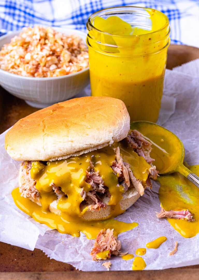 Pulled pork sandwich drizzled with Carolina Gold BBQ Sauce served with slaw.