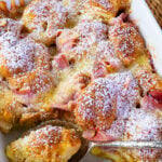 Ham and Cheese Croissant Breakfast Casserole dusted with powdered sugar for serving.