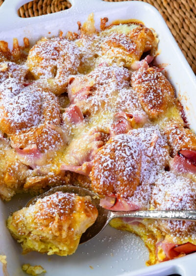 Ham and Cheese Croissant Breakfast Casserole dusted with powdered sugar for serving.