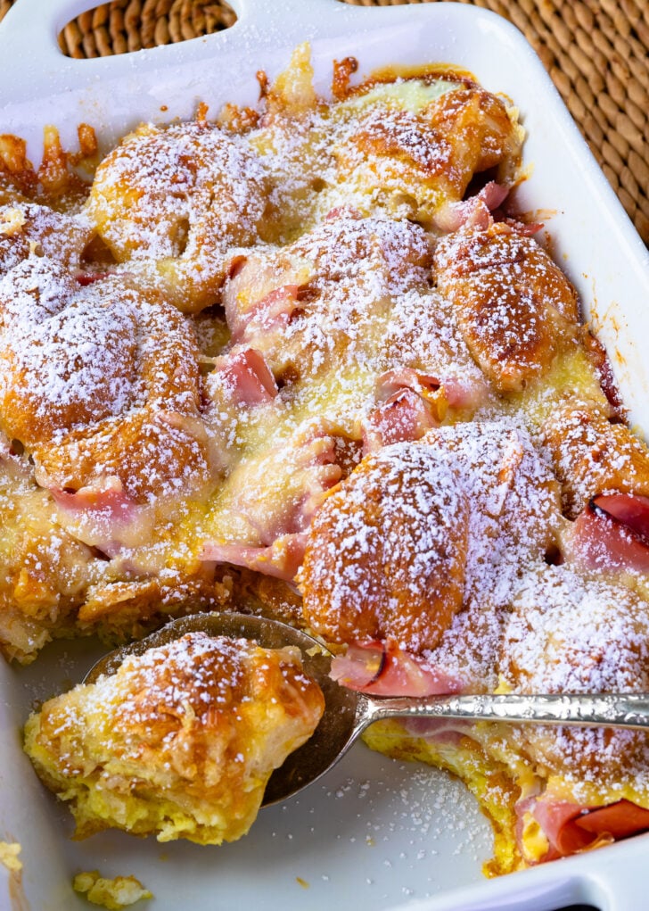 Ham and Cheese Croissant Breakfast Casserole dusted with powdered sugar for serving.