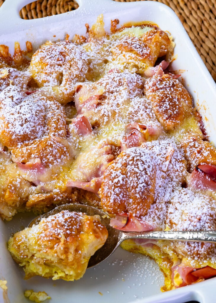 Ham and Cheese Croissant Breakfast Casserole dusted with powdered sugar for serving.