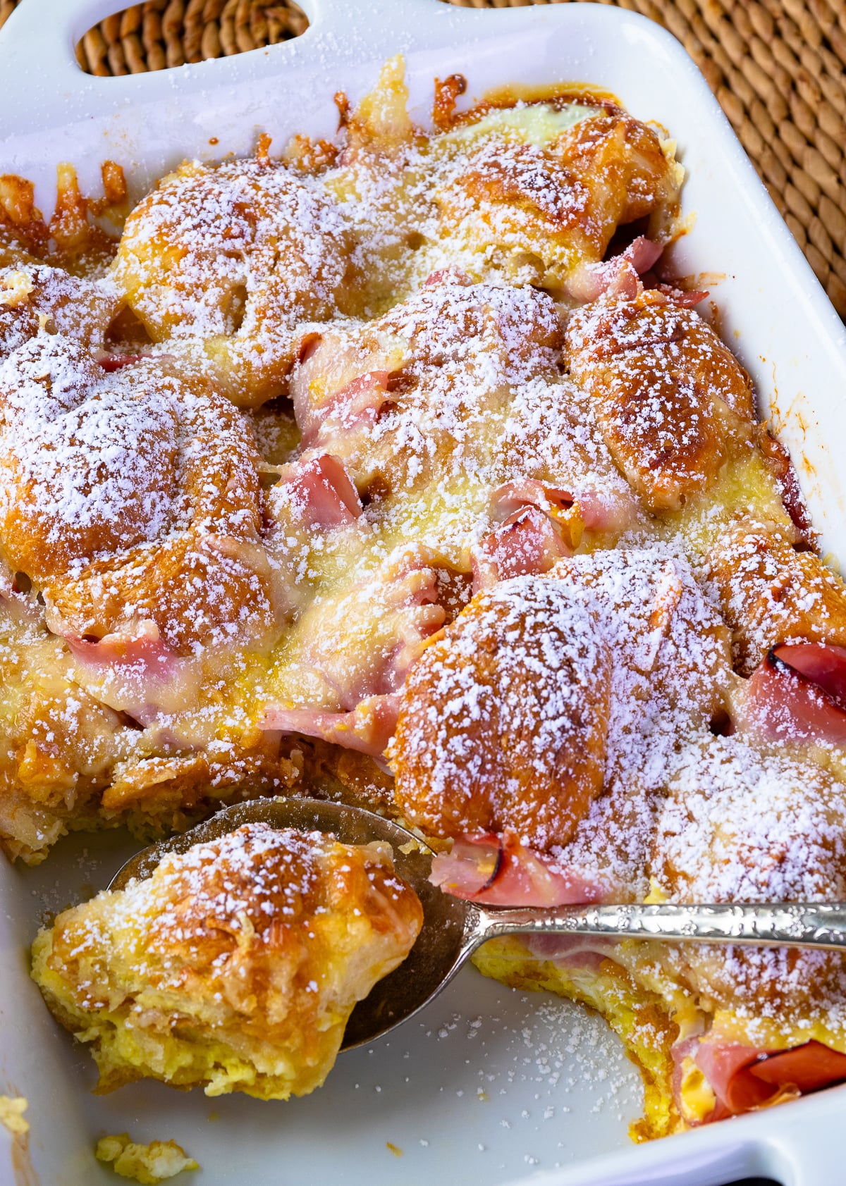 Ham and Cheese Croissant Breakfast Casserole dusted with powdered sugar for serving.