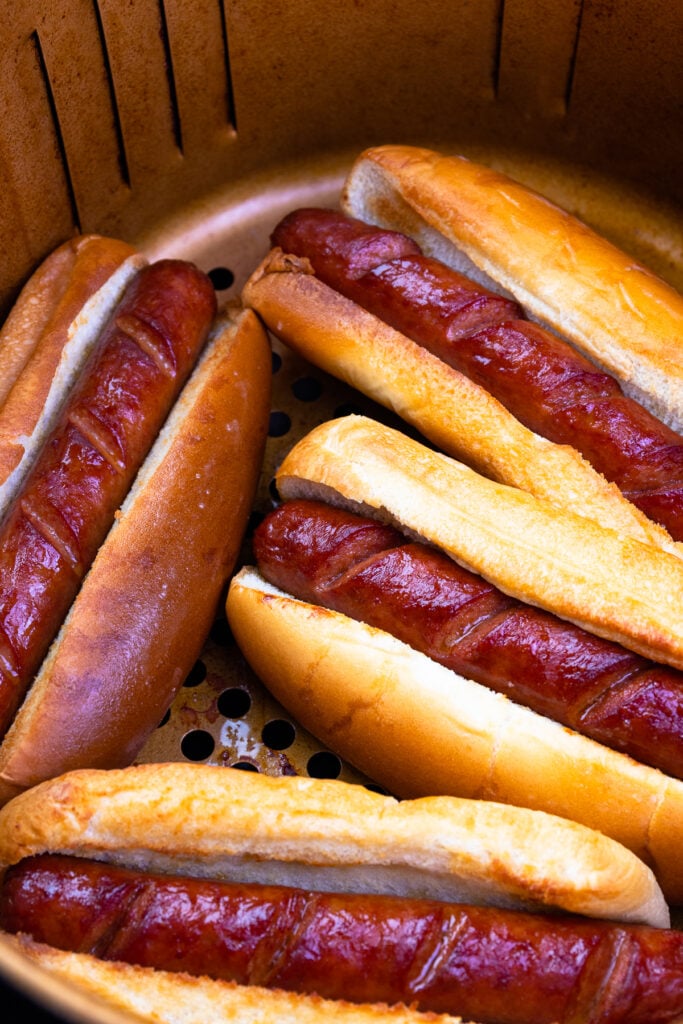 Air Fryer Hot Dogs are easy and absolutely the best! Cooked in less than 10 minutes, these hot dogs are crispy on the outside, juicy on the inside, and nestled in a toasted bun. This is a yummy, fast, easy way to serve up a family favorite.