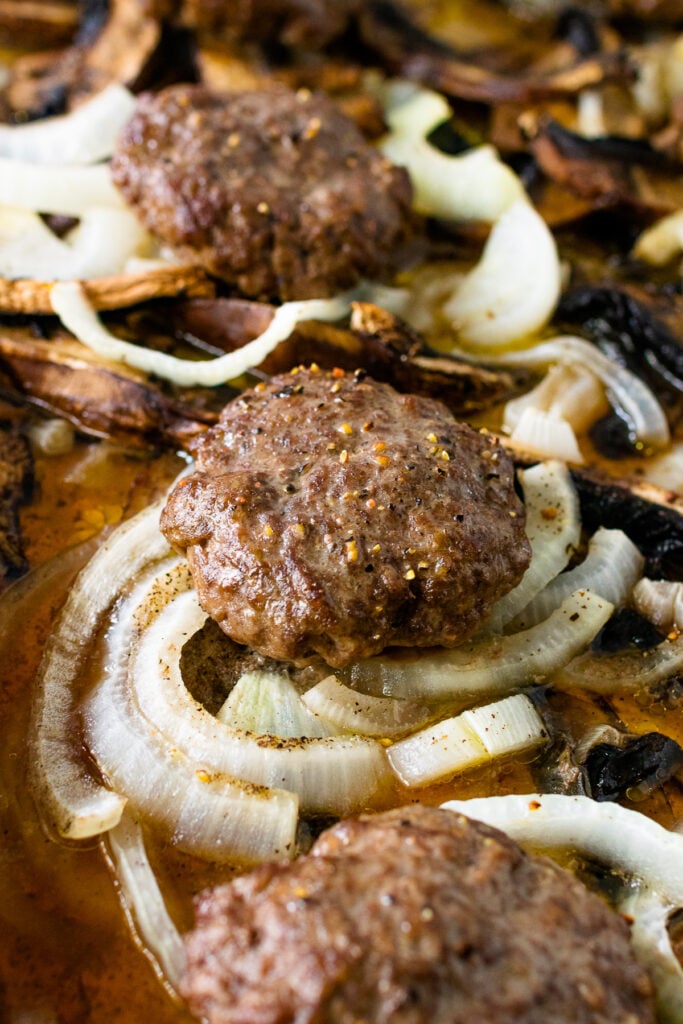 Hamburger Steaks with Mushrooms and Onions cooked on a sheet pan.
