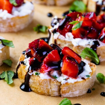 Strawberries and goat cheese with herbs on toast with balsamic drizzle.