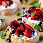 Strawberries and goat cheese with herbs on toast with balsamic drizzle.