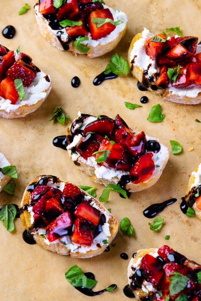 Strawberries and goat cheese with herbs on toast with balsamic drizzle.
