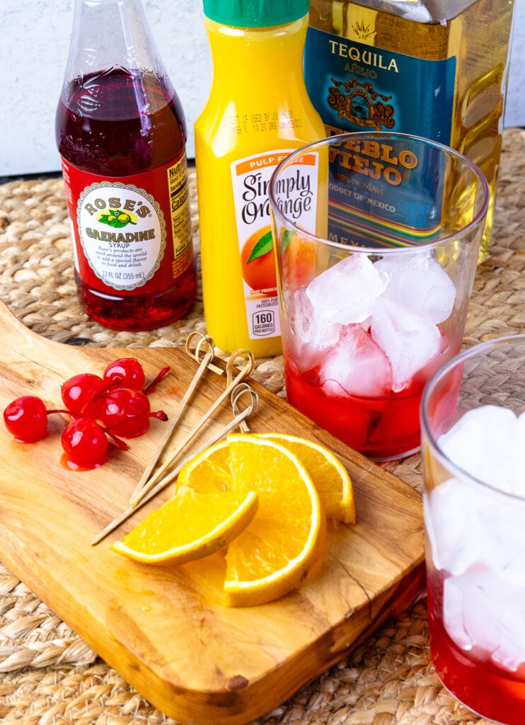 Sliced oranges and cherries with glasses for tequila sunrises.