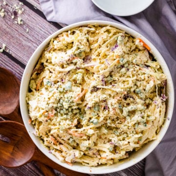 Blue Cheese Coleslaw in a bowl with small white bowl and fork for serving.