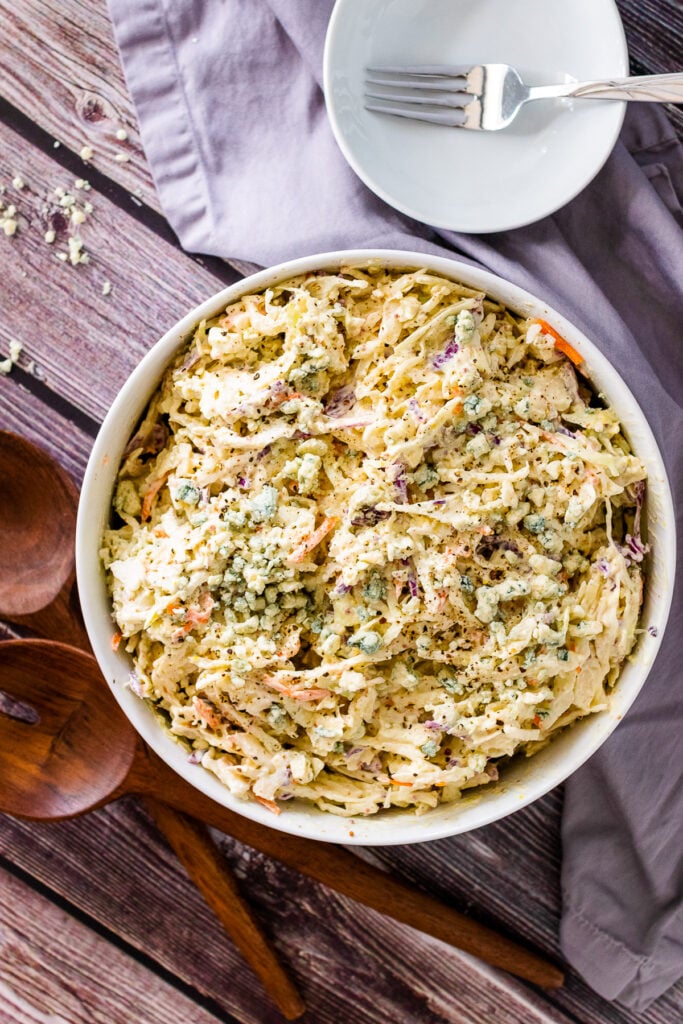 Blue Cheese Coleslaw in a bowl with small white bowl and fork for serving.