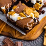 Smores Brownies on a cutting board with parchment paper for serving.