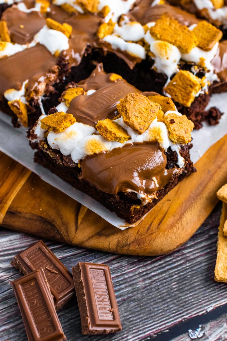 Smores Brownies on a cutting board with parchment paper for serving.