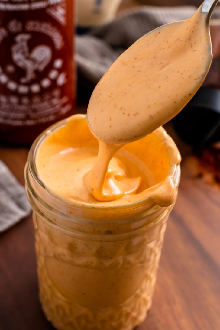 Spicy Mayo Sauce in a jar and a spoon for serving.