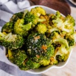 Super easy roasted broccoli bowl close-up showing seasoned florets with garlic and red pepper flakes in white dish