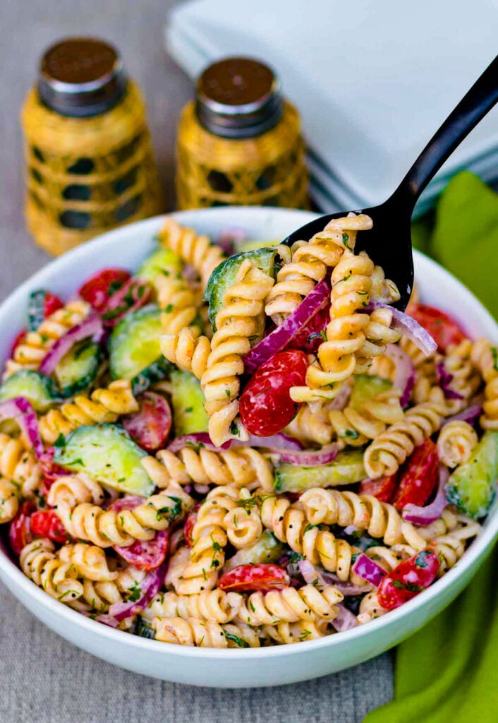 Creamy Tomato Cucumber Pasta Salad made with a simple dressing with fresh herbs and red onions.