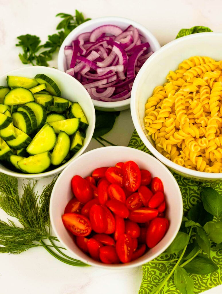 Creamy Tomato Cucumber Pasta Salad made with a simple dressing with fresh herbs and red onions.