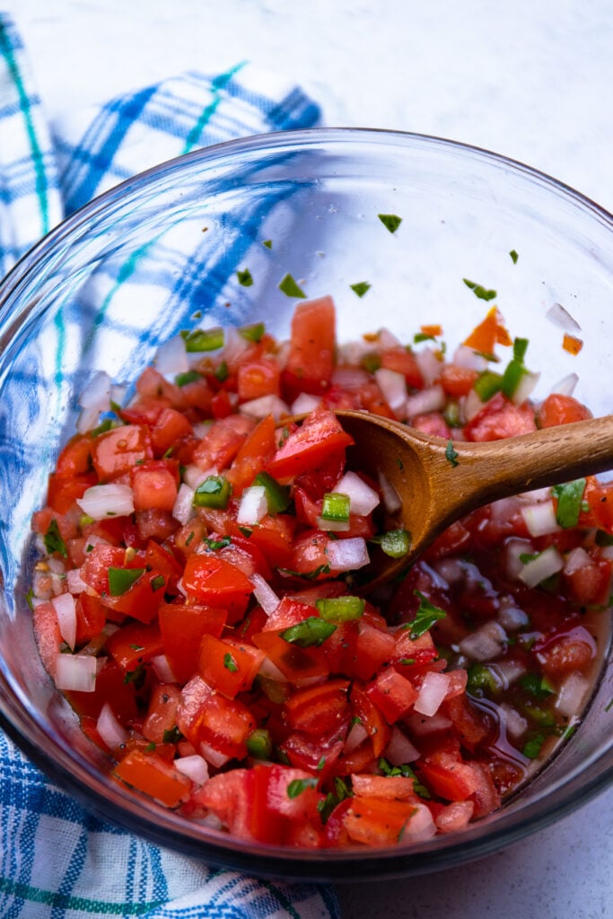 Tomato Relish with onions, parsley and jalapenos mixed in a bowl.