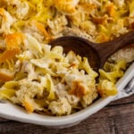 Creamy Chicken Casserole in a white casserole dish with a wooden spoon for serving.