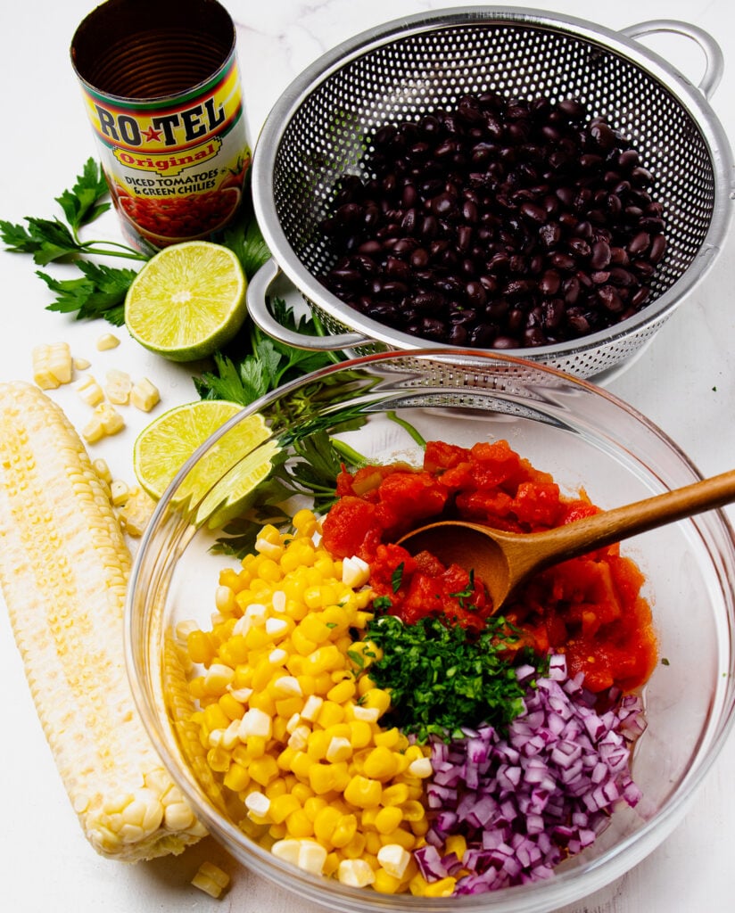 Corn, black beans, parsley, red onion and tomatoes for salsa recipe.