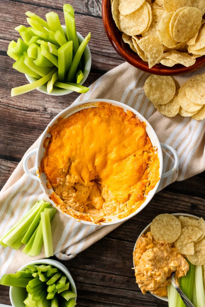 Celery, tortilla chips in bowls with Buffalo Chicken Dip.