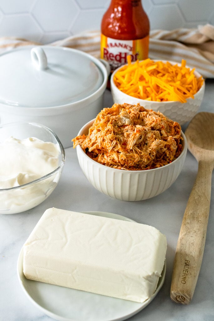 Ingredients for Buffalo Chicken Dip including cream cheese, buffalo chicken, and a few other tasty ingredients.