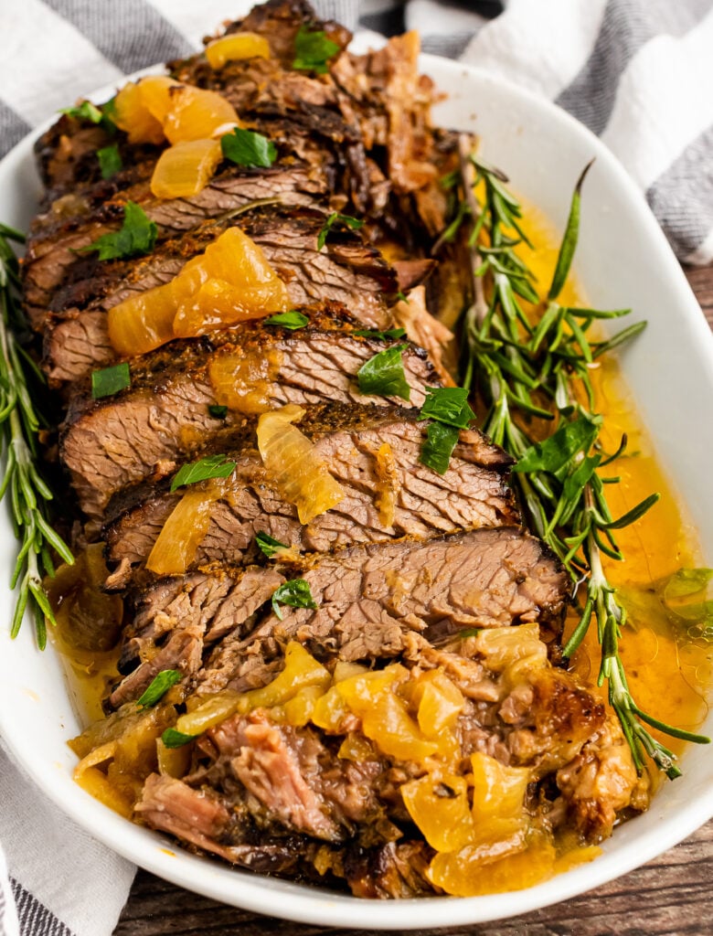 Slow Cooker Pot Roast on a white platter with fresh rosemary.