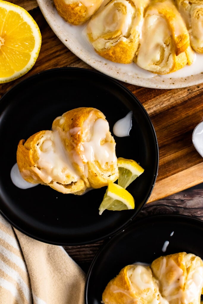 2 slices of Crescent Roll Cream Cheese Danish on a black plate with lemon slices.