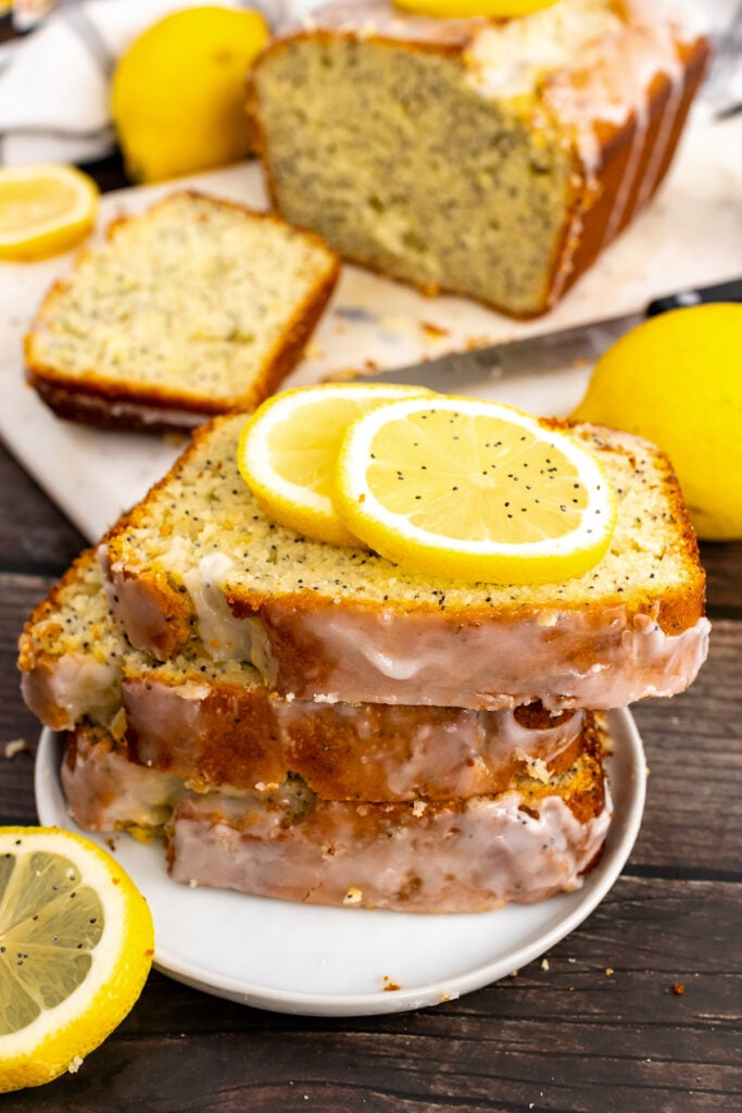 Slices of homemade Lemon Poppy Seed Cake on a small plate with lemon slices.
