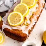 Lemon Poppy Seed Cake on a white board with lemon slices.