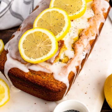 Lemon Poppy Seed Cake on a white board with lemon slices.