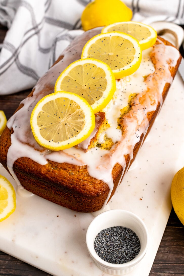 Lemon Poppy Seed Cake on a white board with lemon slices.