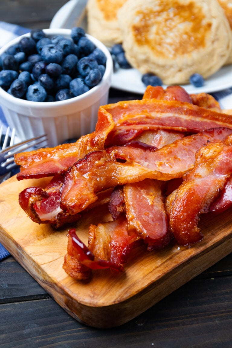 Crispy bacon strips on wooden board with blueberries and whipped cream dip, airfryer board hero breakfast spread