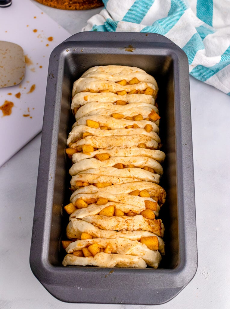 Unbaked apple cinnamon pull apart bread in a loaf pan.