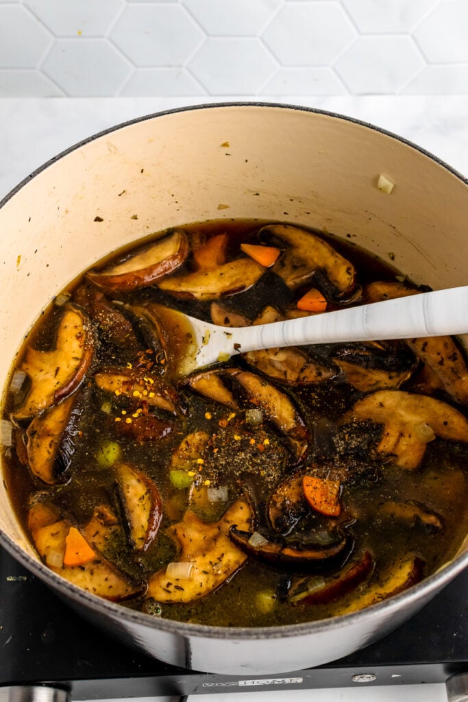 After the veggies have been properly sauteed, warm, rich stock is poured in, filling the grey stock pot half way. Sprinkled on top of this beautiful soup are several seasonings including salt, pepper, and thyme.