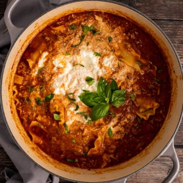 Gray stock pot with Lasagna Soup with ricotta cheese and fresh basil.