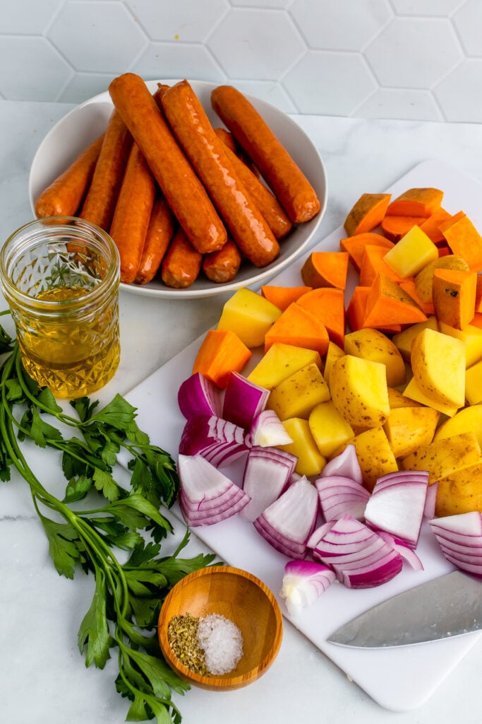 Beef brats, red onions, yellow and sweet potatoes with oil and seasoning.