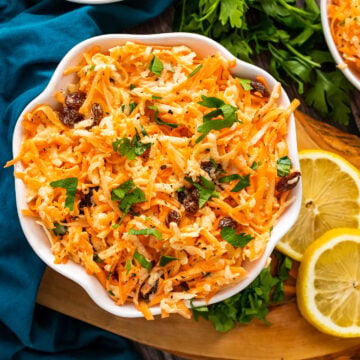 Carrot Apple Salad with fresh parsley in a white bowl.