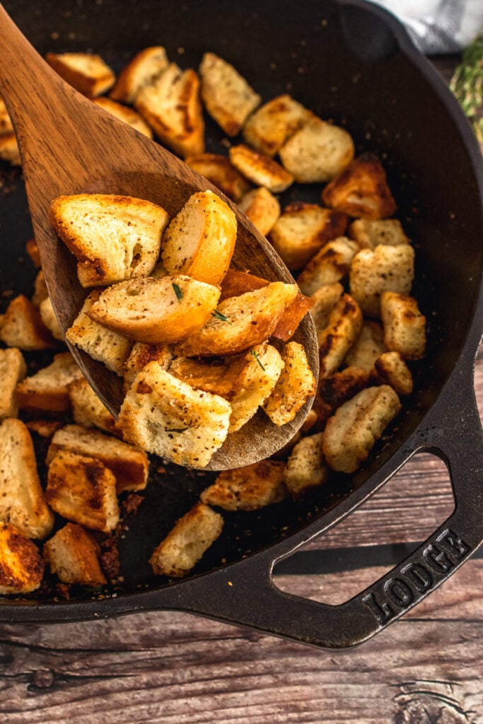 Homemade croutons served on a wooden spoon.